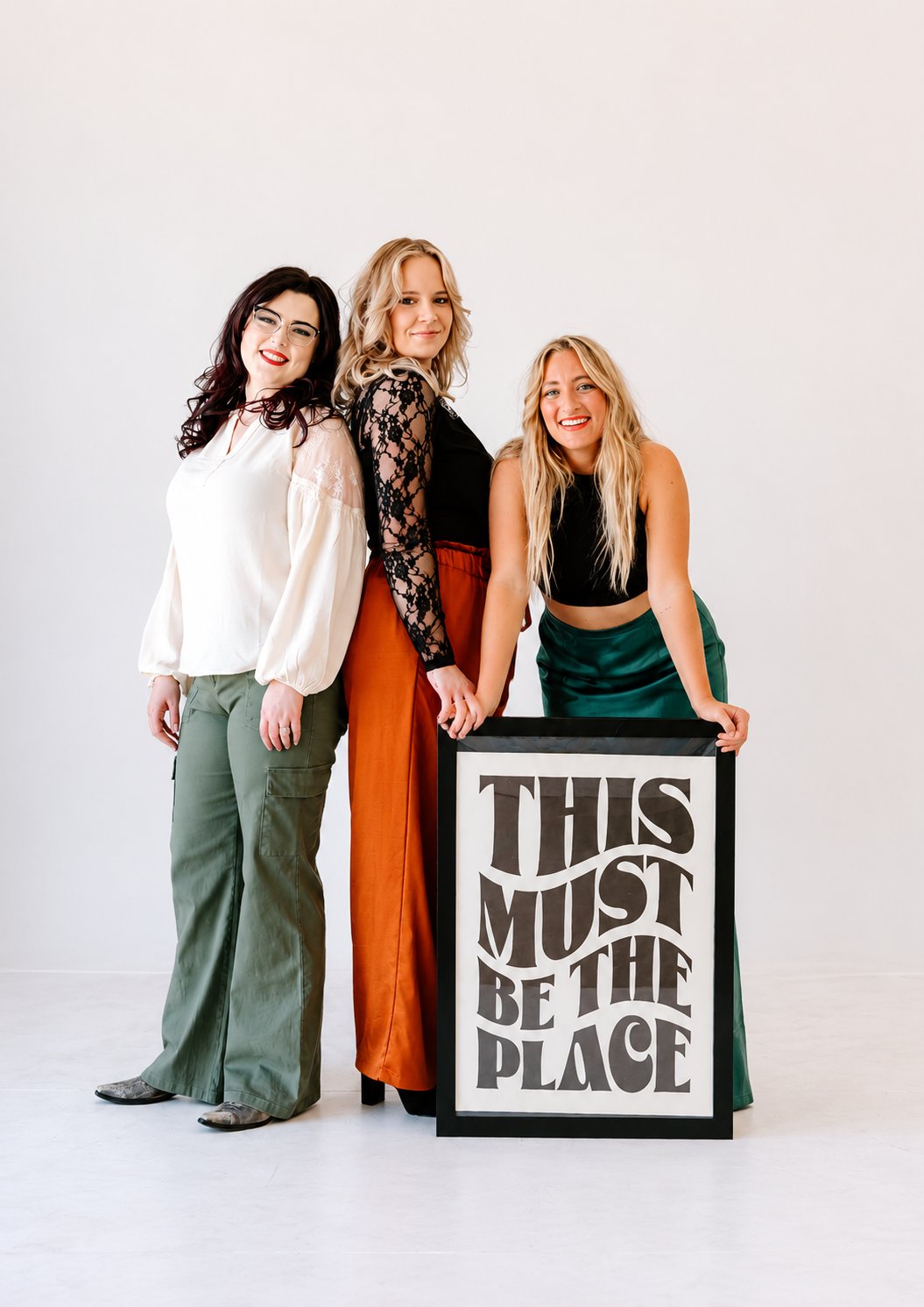 The three stylists of Rooted Beauty Co. standing together in their studio